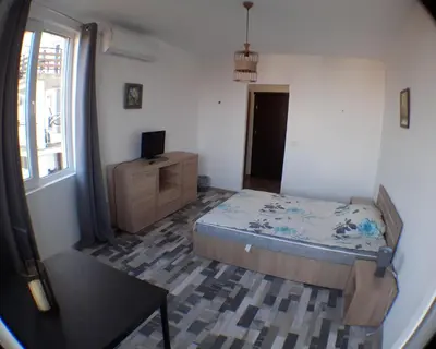 a bedroom with a bed and a table and a window at Sunshine Byala 2 in Byala