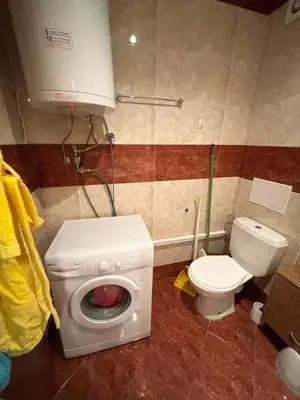 a bathroom with a washing machine and a toilet at 17 pools in Fort Noks Grand in Sveti Vlas