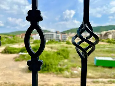 a iron fence with a view of a field at Menada Sea Dreams Apartments in Sveti Vlas