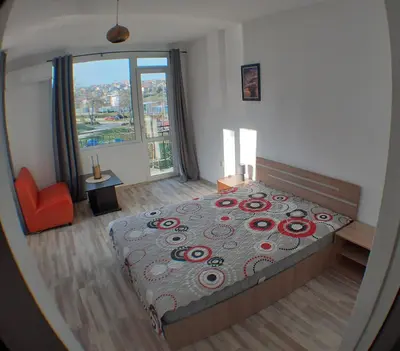 a bedroom with a large bed and a large window at Sunshine Byala in Byala