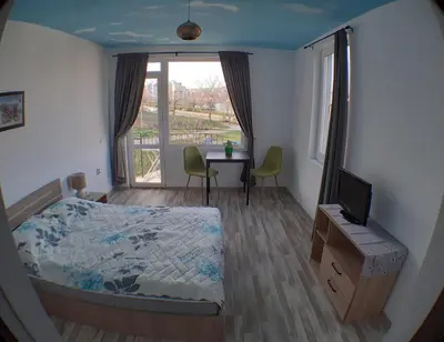 a bedroom with a bed and a table with a television at Sunshine Byala in Byala