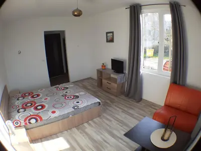 a bedroom with a bed and a chair and a window at Sunshine in Byala