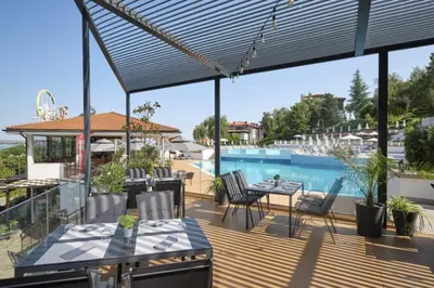 a patio with a table and chairs and a pool at Marina Trio in Sozopol