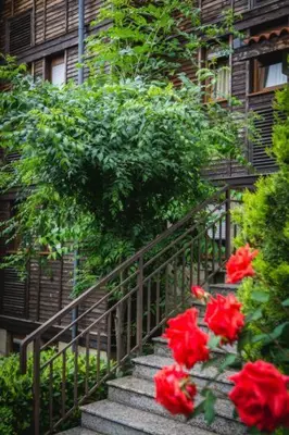 a staircase with red flowers in front of a building at Marina Trio in Sozopol