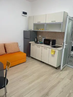 a kitchen with an orange couch in a room at Aqva blue apartments in Sunny Beach