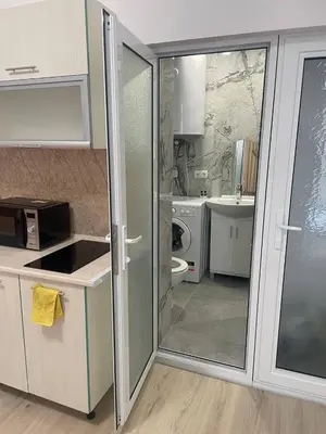 a kitchen with a glass door leading to a bathroom at Aqva blue apartments in Sunny Beach