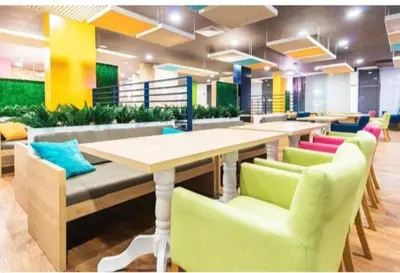 a cafeteria with a long table and colorful chairs at Privite apartment hotel Admiral plaza in Sunny Beach