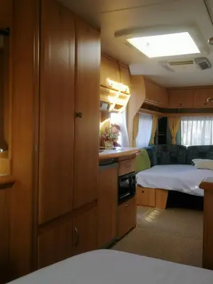 a room with a kitchen and a bed in a train at Каравана Сий-я-на in Sozopol