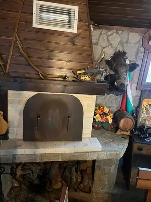 a large stone fireplace in a room with at Семеен хотел Звезда in Sŭdievo