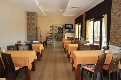 a dining room with tables and chairs and a television at Семеен хотел Звезда in Sŭdievo