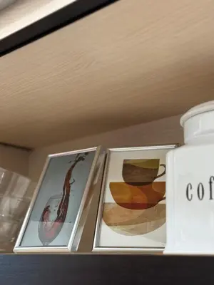 a shelf with two pictures and a bottle of coffee at Dayanas Suite in Varna City
