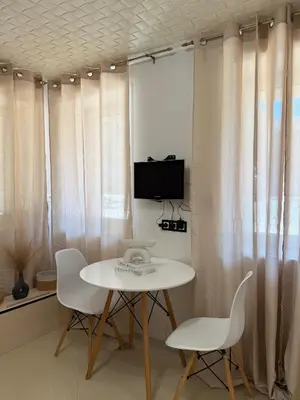 a room with a table and chairs and a tv at Dayanas Suite in Varna City