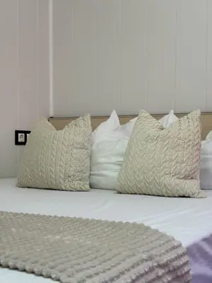 a bed with three pillows and a blanket on it at Dayanas Suite in Varna City