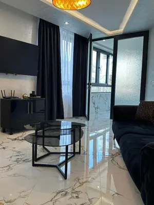 a living room with a glass table and a couch at Luxury Apartment with Parking Just Steps from the Beach in the Heart of Burgas! in Burgas City