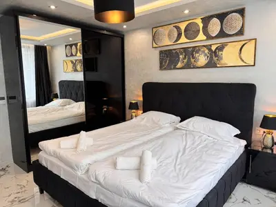 a bedroom with a large bed and a large mirror at Luxury Apartment with Parking Just Steps from the Beach in the Heart of Burgas! in Burgas City