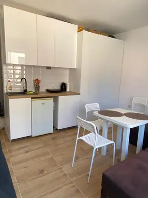 a kitchen with white cabinets and a table and chairs at Avalon Lux in Sunny Beach
