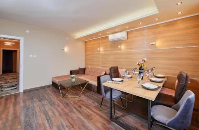 a dining room with a table and a couch at Luxury Apartment Saint George Beauty and Style in Sveti Vlas