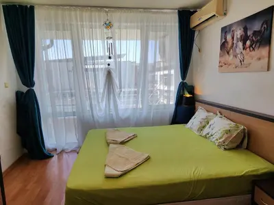 a bedroom with a green bed in front of a window at Nev 1 in Burgas City
