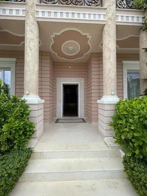 a pink house with columns and a hallway at Luxury Villa in Sozopol in Sozopol