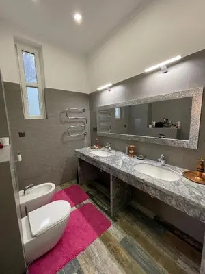 a bathroom with two sinks and a toilet and a mirror at Luxury Villa in Sozopol in Sozopol