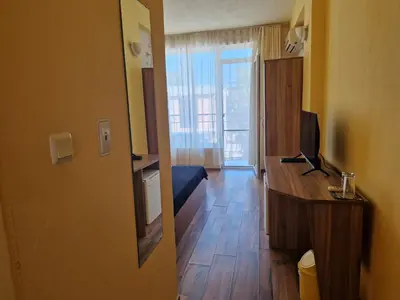 a room with a bedroom with a television and a desk at HOUSEDENz in Chernomorets