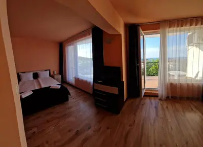 a bedroom with a bed and a large window at HOUSEDENz in Chernomorets