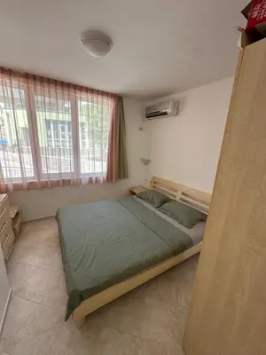 a bedroom with a bed in a room with windows at Apartament Sunset Kosharitsa - Slunchev briag in Kosharitsa
