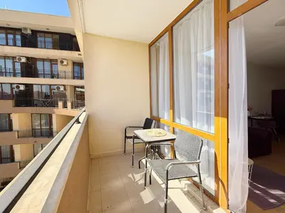 a balcony with chairs and a table and a window at Luxor Zaks Apartments in Sveti Vlas