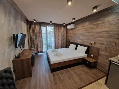 a bedroom with a white bed and a wooden wall at MitProt Panorama Bay 2 Luks Studio 29 in Sveti Vlas