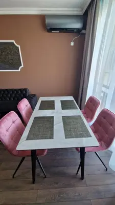 a table with pink chairs in a room at MitProt Panorama bay 2 Luks Apartment 175 in Sveti Vlas