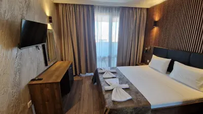 a hotel room with a large bed and a television at MitProt Panorama bay 2 Luks Apartment 175 in Sveti Vlas