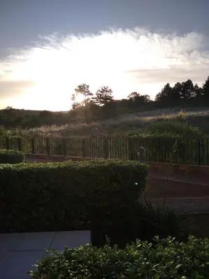 a person standing in a yard with the sun setting at Studio Quatro - South Pearl - Sozopol in Sozopol