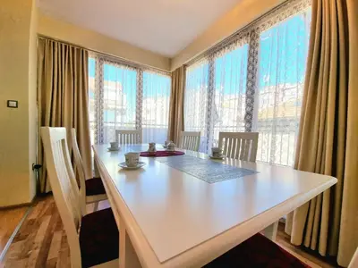 a white table in a room with large windows at Sunny View Apartment with Garage in Burgas City