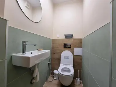a bathroom with a sink and a toilet and a mirror at Sunny View Apartment with Garage in Burgas City