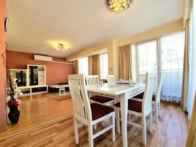 a dining room with a white table and chairs at Sunny View Apartment with Garage in Burgas City