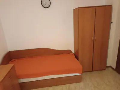 a bedroom with a bed and a cabinet and a clock at Stamopolu apartament 1 in Primorsko