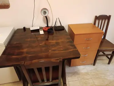 a wooden table and a desk with a lamp and a dresser at Stamopolu apartament 1 in Primorsko