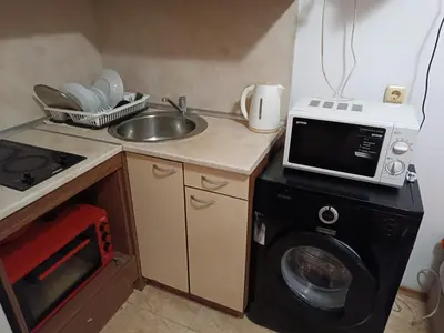 a kitchen with a microwave and a washing machine at Stamopolu apartament 1 in Primorsko
