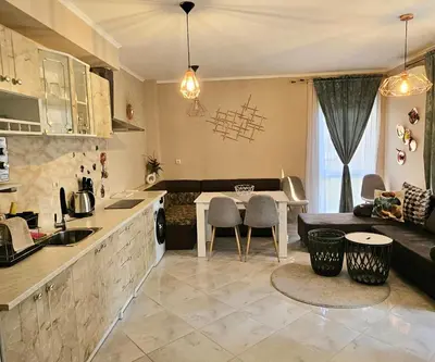 a kitchen and living room with a couch and a table at Sunny Garden Deluxe in Burgas City