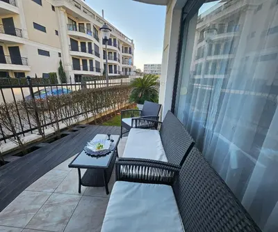 a patio with two chairs and a table on a balcony at Rose Garden Deluxe in Chernomorets