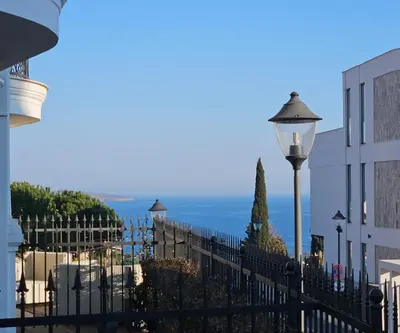 a black fence with a view of the ocean at Rose Garden Deluxe in Chernomorets