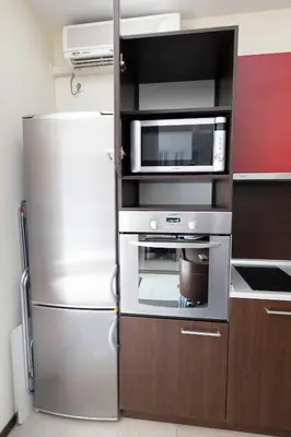 a kitchen with a stainless steel refrigerator and a microwave at Reina Apart Kamelia Garden in Sunny Beach