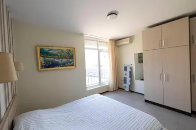 a bedroom with a white bed and a window at Reina Apart Kamelia Garden in Sunny Beach