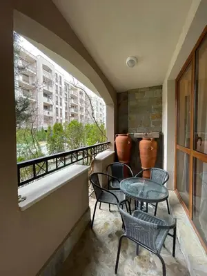 a balcony with chairs and a table and a window at Cascadas Family Resort in Sunny Beach