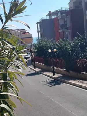 a street with a fence and some bushes and buildings at Studio in Sea Breeze Complex Sveti Vlas in Sveti Vlas
