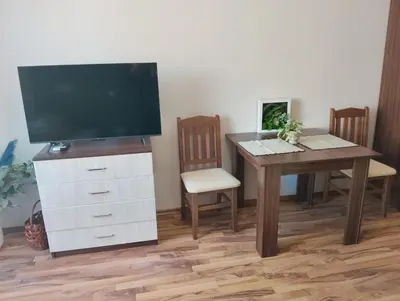 a living room with a table and a television on a dresser at Studio in Sea Breeze Complex Sveti Vlas in Sveti Vlas
