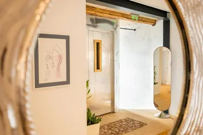 a mirror in a hallway with a drawing on the wall at Apartment Musala N 05 in Varna City