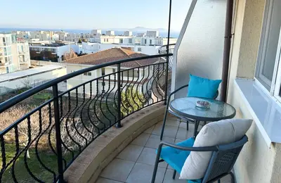a balcony with a table and chairs and a view at Sea Sunrise Apartment in Burgas City