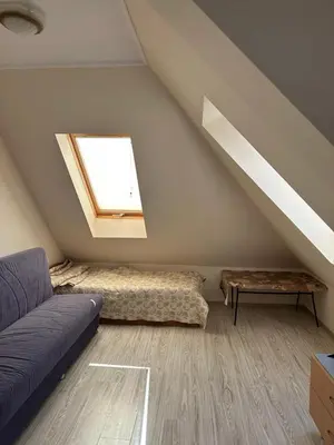 a attic room with a couch and a window at Persani 3 Sanny Beach in Sunny Beach