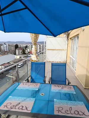 a view from the top of a balcony with a blue umbrella at Sunny Beach Center Apartment in Sunny Beach